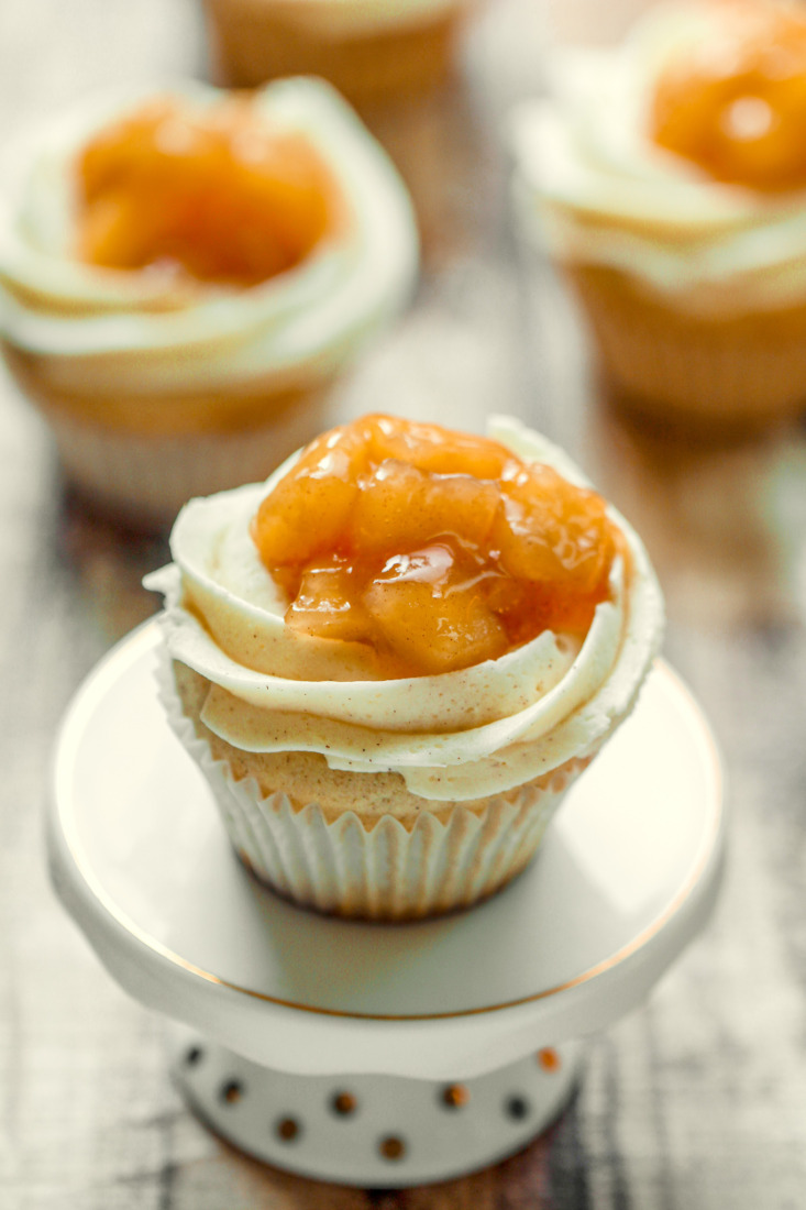 These Apple Pie Cupcakes feature a fluffy vanilla cinnamon cupcake filled with luscious apple pie filling all topped off with a vanilla cinnamon buttercream and even more apple filling! It's apple pie in cupcake form!