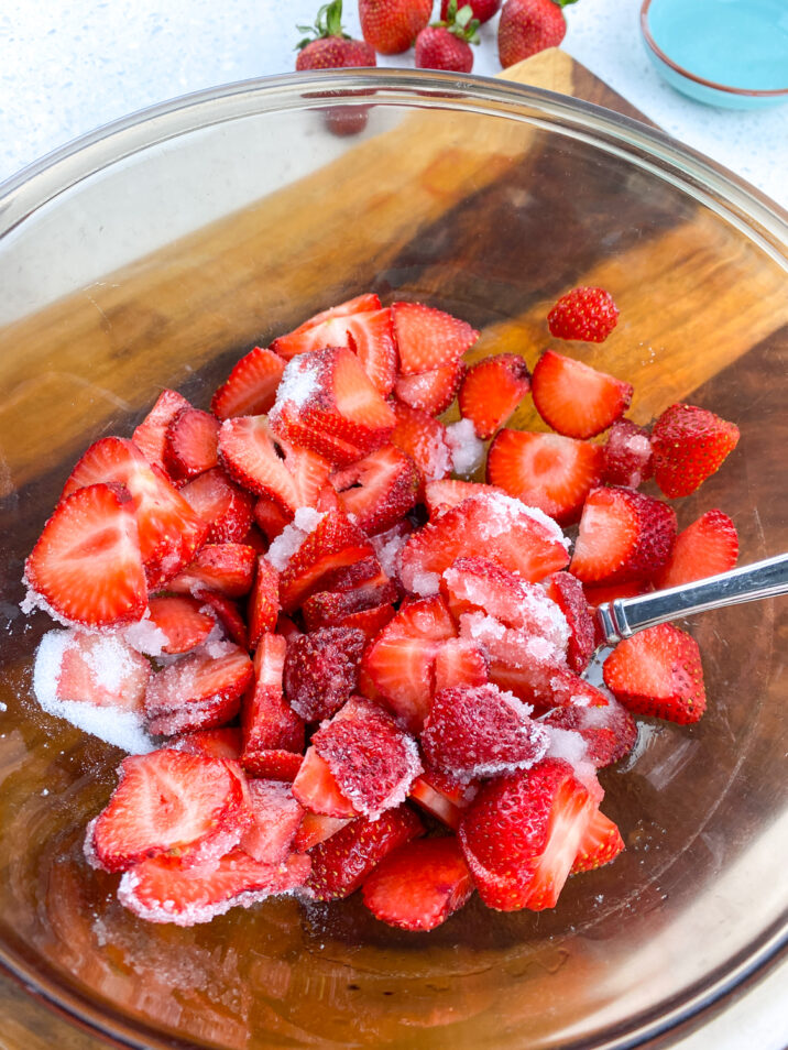 Strawberries and sugar in a bowl.