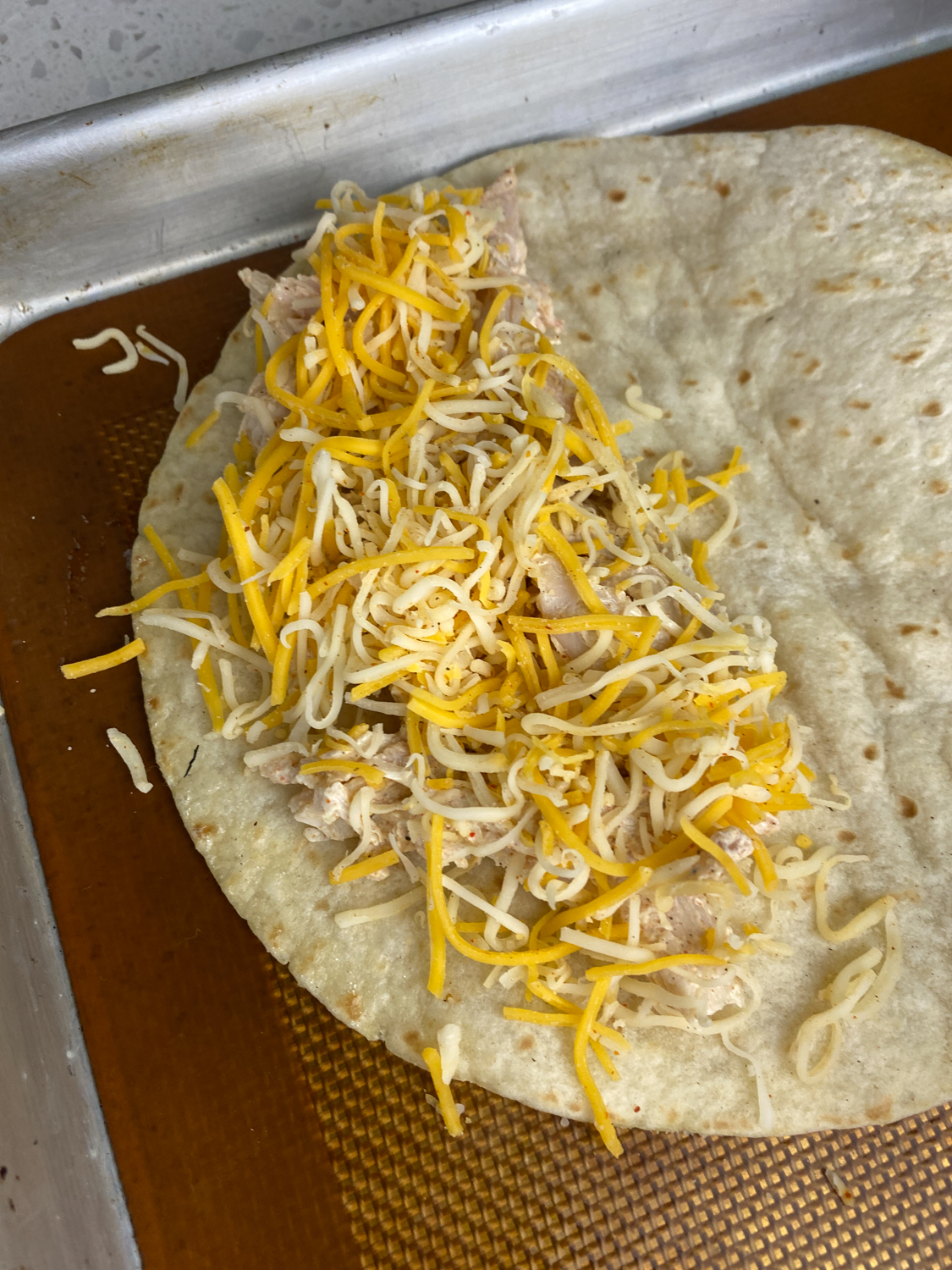 tortilla topped with chicken and cheese