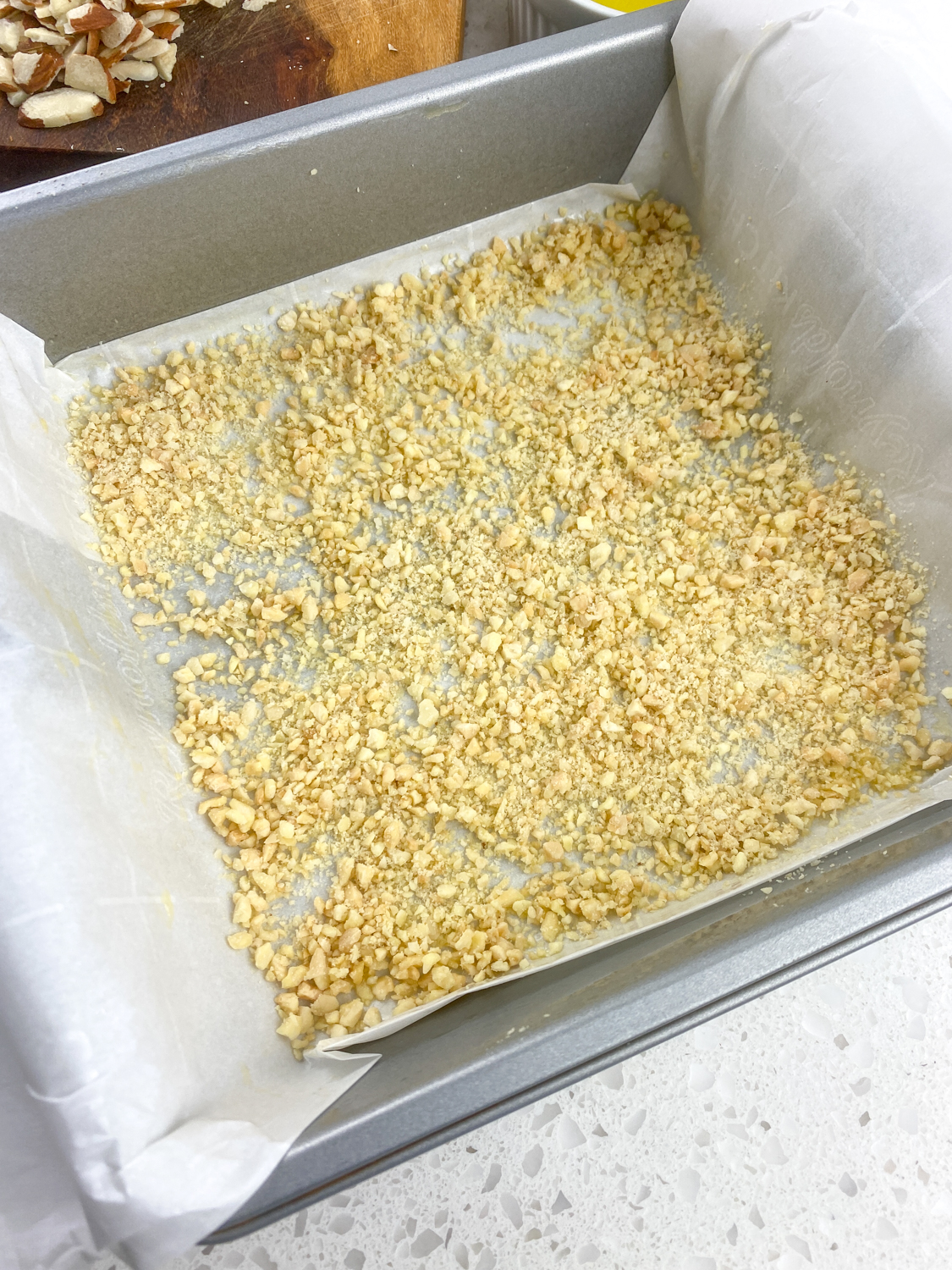 Butter melted over the parchment and a layer of ground almonds sprinkled over.