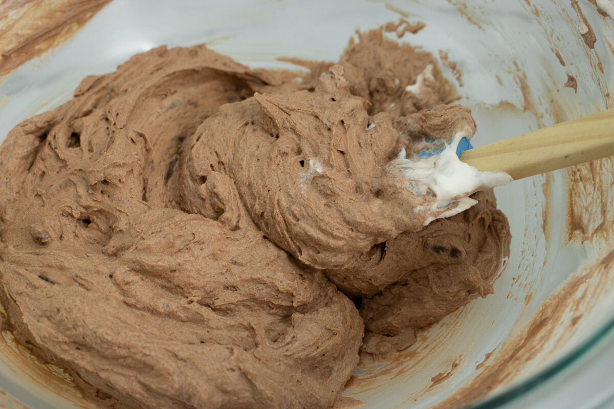 Folding the chocolate into the whipping cream.