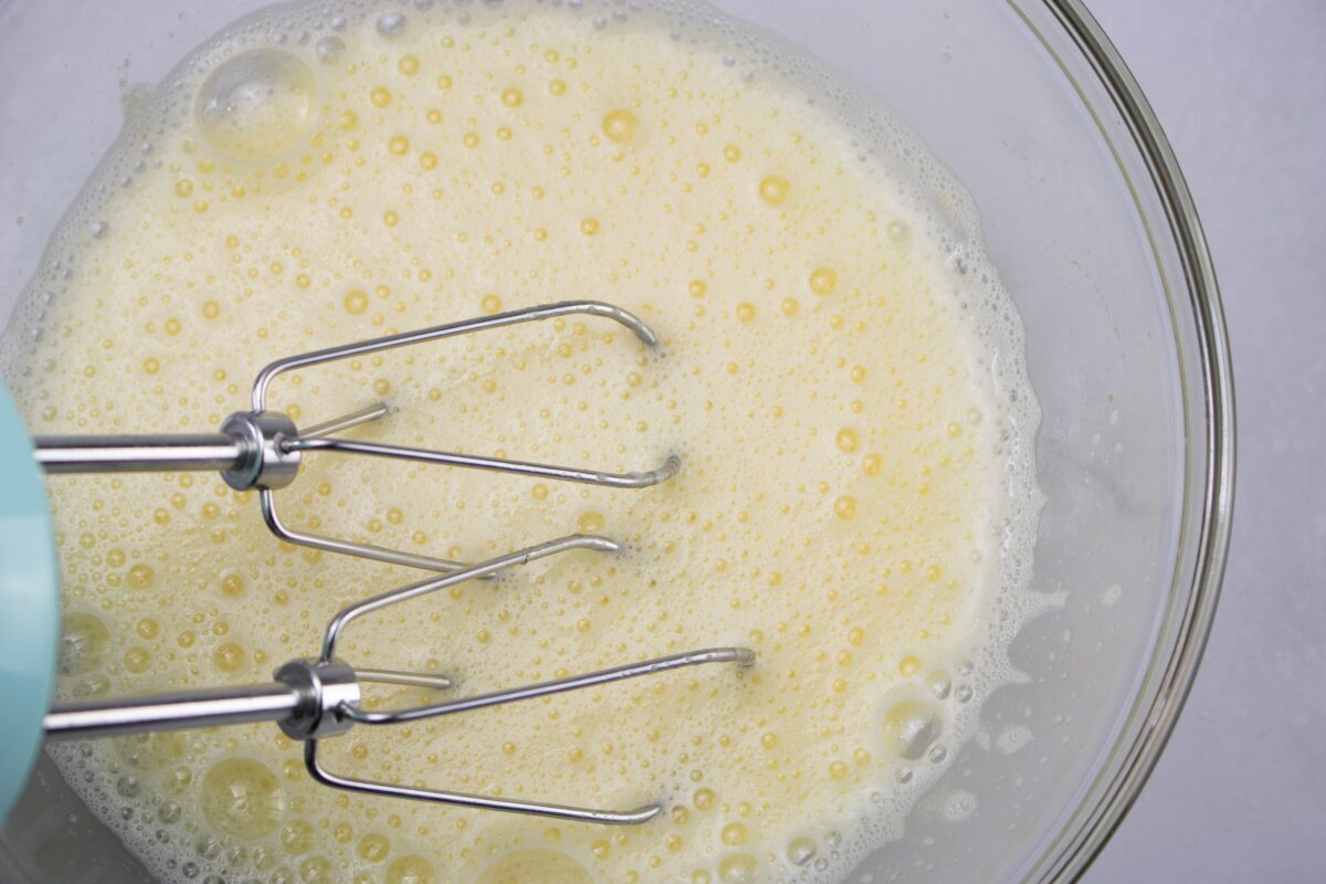 Beating eggs with an electric mixer.