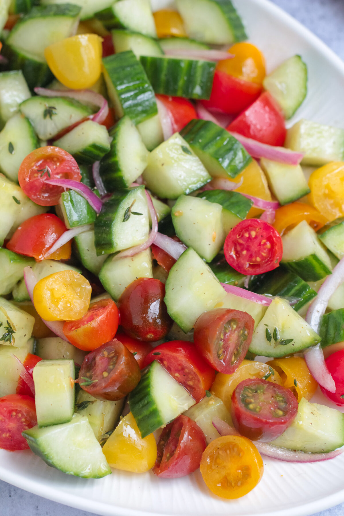 Fresh cucumber tomato salad with cherry tomatoes, red onion, thyme, and a simple vinaigrette. An easy summer side dish for any meal.